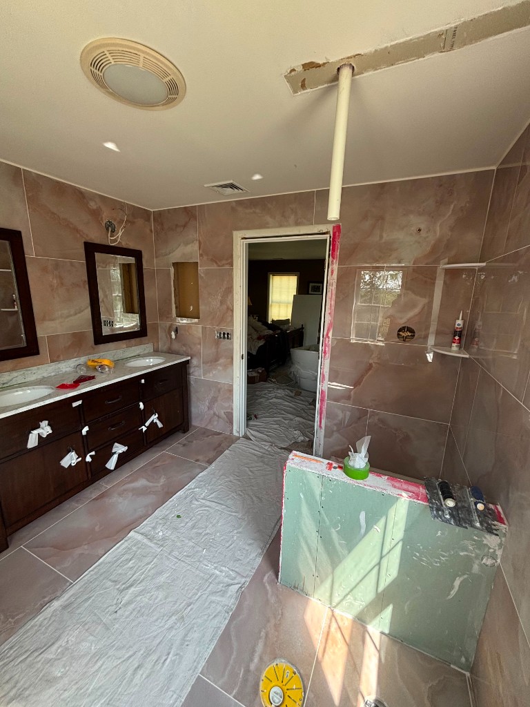 Bathroom remodel with marble tile walls and double vanity