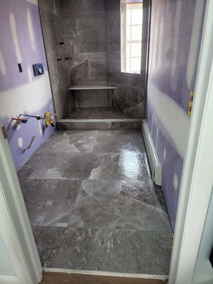 Grey porcelain tile bathroom with walk-in shower and bench