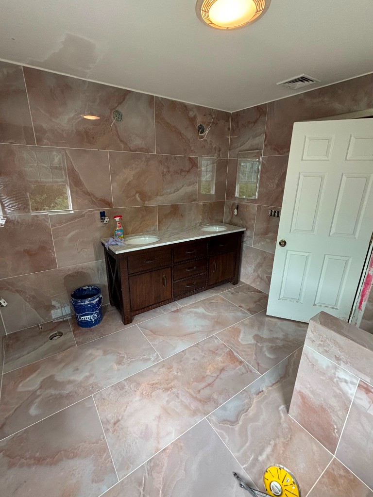 Double vanity bathroom with marble tile walls in progress